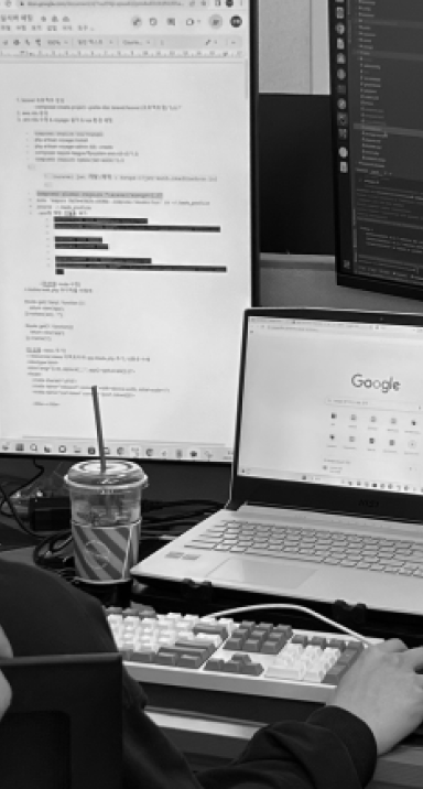 A team member of Else working on documents with two monitors.